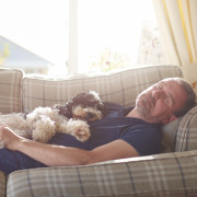 man sleeping on couch with his dog