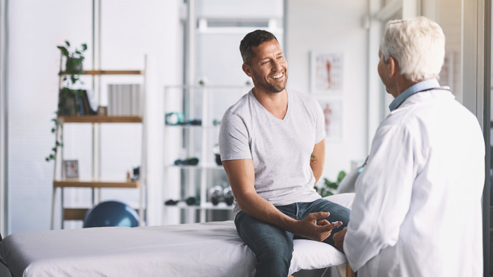senior doctor giving his male patient a thorough checkup during his consultation