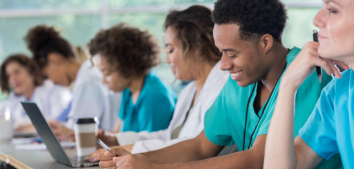 Diverse pre-med students take notes during class