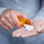 man taking pills pills in his hand