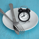 alarm clock on plate with fork and knife fastting diet