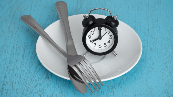 alarm clock on plate with fork and knife fastting diet
